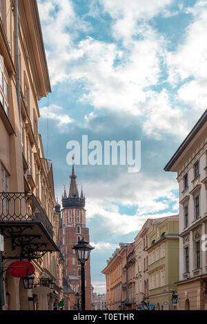 Straße in der Altstadt von Krakau. Stadtbild und St. Marys Basilika. Backsteingotik Kirche Unserer Lieben Frau in den Himmel durch den blauen Himmel in Krakau, Polen Stockfoto