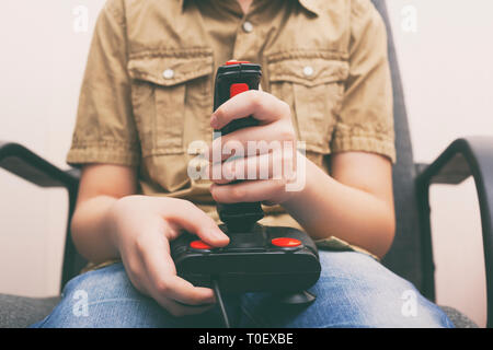 Junge Junge spielt Video Spiel mit einem Retro Joystick. Gaming Joystick aus der Mitte der 80er Jahre. Close Up. Stockfoto