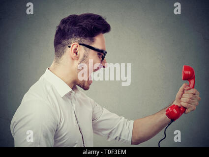 Wütend Geschäftsmann kreischen auf einem roten Telefon Stockfoto
