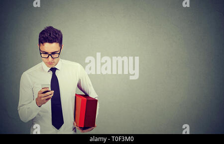 Geschäftsmann mit Mobiltelefon Holding eine Lieferung, Stockfoto