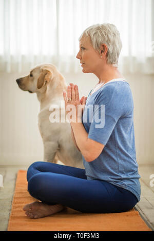 Reife Frau auf einem Bein stehen beim Üben von Yoga. Stockfoto
