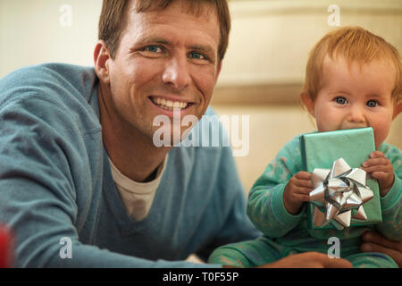 Gerne Vater Eröffnung präsentiert mit seiner kleinen Tochter. Stockfoto