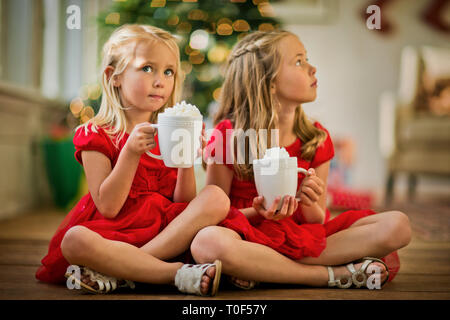 Zwei junge Mädchen trinken heiße Schokolade. Stockfoto