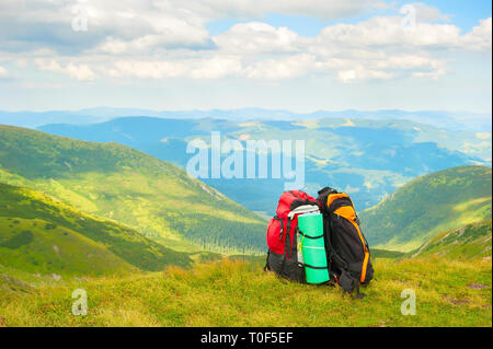 Zwei bunte Wanderer Rucksäcke am grünen Hang, Scenic Karpaten Landschaft im Hintergrund, Ukraine Stockfoto