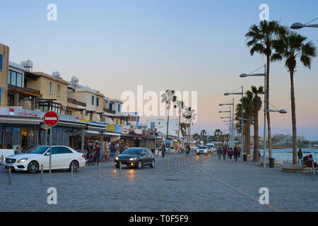 PAPHOS, RAUCHERREGELUNG - Februar 13, 2019: Menschen zu Fuß von Zypern Promenade in der Dämmerung. Paphos - berühmte touristische Destination in Zypern Stockfoto