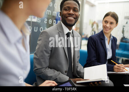 Lächelnd afrikanischen Geschäftsmann, der in Sitzung Stockfoto