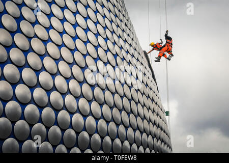 Die Stierkampfarena, Birmingham, UK, 19. März 2019. Eine Gruppe von Seil Reinigung und Wartung Fremdfirmen arbeiten in luftiger Höhe auf dem berühmten Fassade der Selfridges in Birmingham Bull Ring Einkaufszentrum. Die Arbeit ist Teil einer geplanten laufenden Projekts. Die selfridges Gebäude ist in 15.000 überdachte Aluminium Scheiben auf einem blauen Hintergrund gesponnen. Credit: Imageplotter/Alamy leben Nachrichten Stockfoto