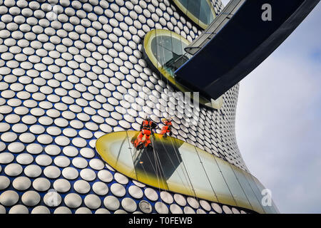 Die Stierkampfarena, Birmingham, UK, 19. März 2019. Eine Gruppe von Seil Reinigung und Wartung Fremdfirmen arbeiten in luftiger Höhe auf dem berühmten Fassade der Selfridges in Birmingham Bull Ring Einkaufszentrum. Die Arbeit ist Teil einer geplanten laufenden Projekts. Die selfridges Gebäude ist in 15.000 überdachte Aluminium Scheiben auf einem blauen Hintergrund gesponnen. Credit: Imageplotter/Alamy leben Nachrichten Stockfoto
