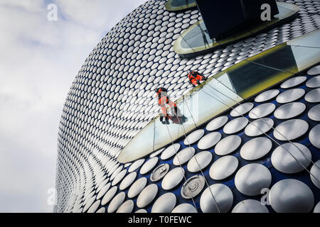 Die Stierkampfarena, Birmingham, UK, 19. März 2019. Eine Gruppe von Seil Reinigung und Wartung Fremdfirmen arbeiten in luftiger Höhe auf dem berühmten Fassade der Selfridges in Birmingham Bull Ring Einkaufszentrum. Die Arbeit ist Teil einer geplanten laufenden Projekts. Die selfridges Gebäude ist in 15.000 überdachte Aluminium Scheiben auf einem blauen Hintergrund gesponnen. Credit: Imageplotter/Alamy leben Nachrichten Stockfoto