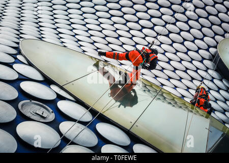 Die Stierkampfarena, Birmingham, UK, 19. März 2019. Eine Gruppe von Seil Reinigung und Wartung Fremdfirmen arbeiten in luftiger Höhe auf dem berühmten Fassade der Selfridges in Birmingham Bull Ring Einkaufszentrum. Die Arbeit ist Teil einer geplanten laufenden Projekts. Die selfridges Gebäude ist in 15.000 überdachte Aluminium Scheiben auf einem blauen Hintergrund gesponnen. Credit: Imageplotter/Alamy leben Nachrichten Stockfoto