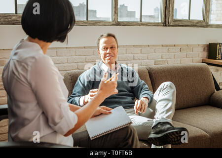 Lächelnd gut aussehender Mann in angenehmen Gespräch mit Dunkelhaarige Arzt Stockfoto