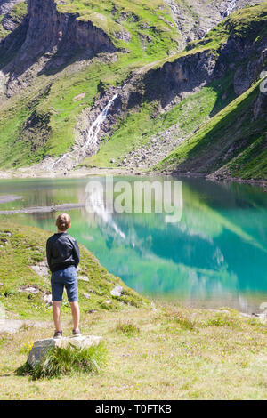 Ein Junge, der gerade die See namens Nassfeld Speicher im Nationalpark Hohe Tauern in Österreich Stockfoto