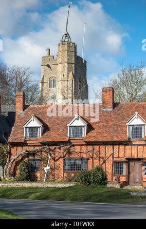 Fachwerk Häuschen mit St. Maria der Jungfrau Kirche auf dem Dorfplatz. Cavendish, Suffolk, East Anglia, Großbritannien. Stockfoto