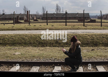Touristische machen ein Foto auf der Bahn zum Haupteingang des Konzentrationslager Auschwitz Birkenau, Polen vom 12. März 2019 Stockfoto