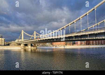 = Krymsky Bridge in einem Winter Tauwetter = Winkel Blick auf die Sonne beleuchtete Krymsky (Krim) Brücke vom Puschkinplatz Ufer der Moskva (Moskau) Fluss in einem Stockfoto