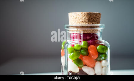 Transparente candy jar voller Süßigkeiten am weißen Tisch Stockfoto