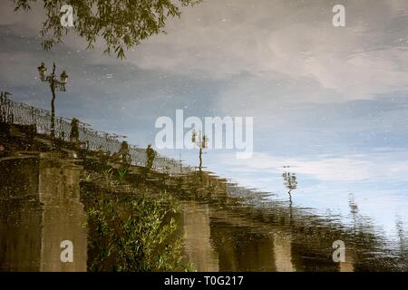 Eine alte Brücke, die sich im Fluss widerspiegelt Stockfoto