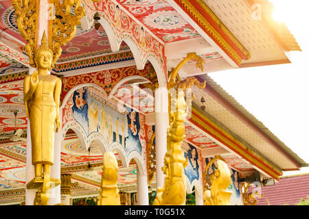 Atemberaubende Aussicht auf eine gold-bedeckten Buddha Statue vor der schönen und bunten Wat That Luang Tai in Vientiane, Laos. Stockfoto