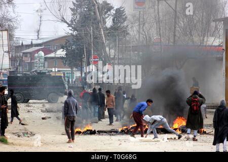 Pulwama, Indien. 19 Mär, 2019. Die Demonstranten während der Auseinandersetzungen mit der Polizei und paramilitärischen Personal gegen den Freiheitsentzug Tod von Rizwan Pandit, an Awantipora im Kaschmir Pulwama Bezirk, etwa 28 Kilometer von Srinagar. Rizwan, einem Lehrer der Schule, wurde von der Polizei von seiner Residenz zwei Tage zurück verhaftet und starb in Polizeigewahrsam. Credit: Muneeb ul-Islam/Pacific Press/Alamy leben Nachrichten Stockfoto