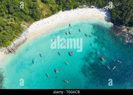 Ansicht von oben, aus der Vogelperspektive einen wunderschönen tropischen Strand mit weißem Sand und türkisfarbenem Wasser, long tail Boote und Menschen zu sonnen. Stockfoto