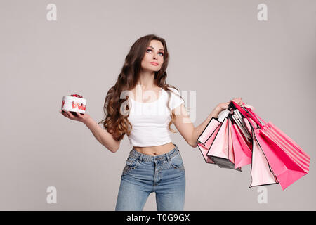 Shopoholic Frau mit Box von leckeren Süßigkeiten auf Hintergrund isolieren. Stockfoto