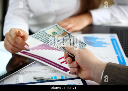 Männliche arm pay Bündel von hundert Dollar Rechnungen Stockfoto