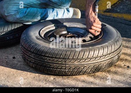 Ein reifen Handwerker Aufpumpen eines Reifens im Freien in einer Tankstelle in Galle, Sri Lanka. Stockfoto