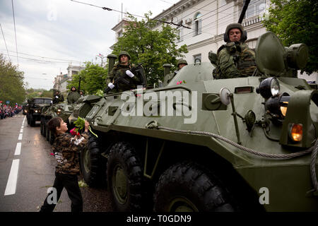 Ein Junge wirft Blumen an die Russische Schützenpanzer BTR-80 während der Militärparade in zentralen Straßen der Stadt Sewastopol, Krim 9 Mai Stockfoto