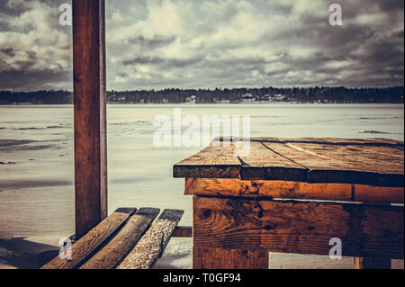 Arbeitsplatte mit Blick auf den Winter Lake. Winter Pavillon am Ufer eines zugefrorenen See. Stockfoto