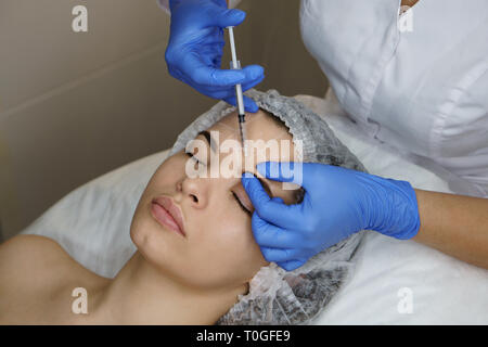 Ästhetische Kosmetologie. Facelift in Spa Salon. Kosmetikerin macht Injektionen Mädchen in der Augenbrauen. Glättung von Falten nachahmen. Close-ups Stockfoto