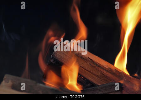 Ein Schuß von brennendem Holz in den Kamin. Close-up. Das Verbrennen von Holz zum Grillen ein. Rauch und Funken. Feuer Hintergrund. Stockfoto