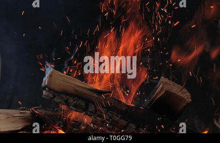 Ein Schuß von brennendem Holz in den Kamin. Close-up. Das Verbrennen von Holz zum Grillen ein. Rauch und Funken. Feuer Hintergrund. Stockfoto