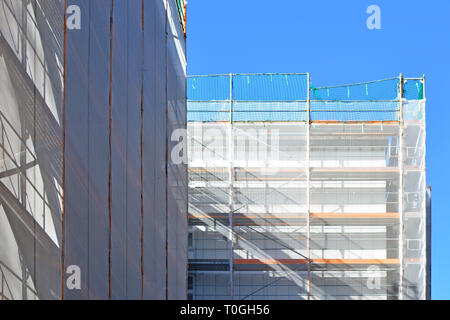 Baustelle mit Gerüst auf, mehrstöckiges Gebäude Fassade während der Sanierung Stockfoto