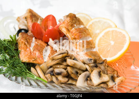 Barschfilet mit Pilzen, Zitrone und Grüns Stockfoto