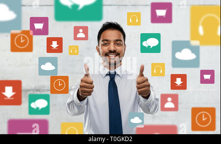 Indischer Geschäftsmann zeigt Daumen hoch über App Icons Stockfoto