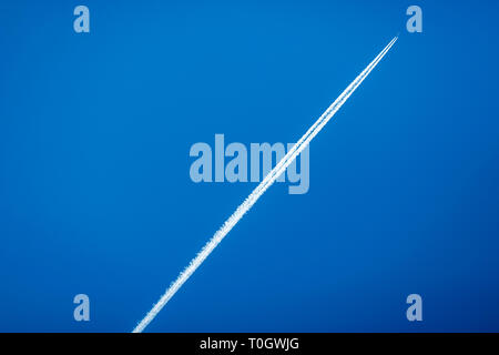 Kommerzielle Fluglinie jet Kondensstreifen über einen klaren, blauen Himmel Stockfoto
