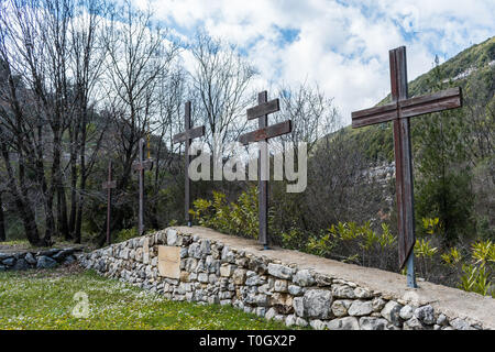 Dies ist eine Erfassung für einen Mehrere christliche Kreuze, das an einer Wand aus Steinen mit einem grünen Wald Hintergrund sitzen Stockfoto