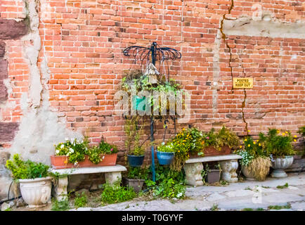 Brick Wall mit steinernen Bänken und Blumen Stockfoto