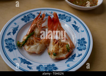 Garnelen in Knoblauch gekocht, ein beliebtes Gericht in Fischrestaurants und Hawker Center in Singapur Stockfoto