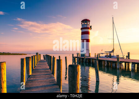 Leuchtturm am Neusiedler See, Podersdorf am See, Burgenland, Österreich. Leuchtturm bei Sonnenuntergang in Österreich. Hölzerne Seebrücke mit Leuchtturm in Podersdorf auf Lak Stockfoto