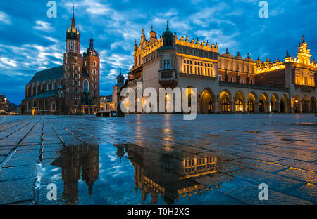 Foto der Altstadt von Krakau, Rynek Główny Marktplatz mit großen Pfütze im Winter Sonnenaufgang am regnerischen Tag, Polen Stockfoto