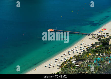 Luftaufnahme von tropischen Sandstrand mit Palmen und Sonnenschirmen von Luxus Hotel am sonnigen Tag. Stockfoto