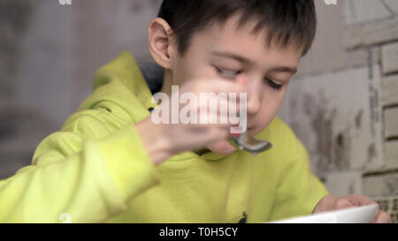 Junge mit einem Appetit Suppe isst, haben Spaß Stockfoto