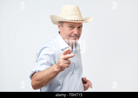 Reifer mann Cowboy tragen im Studio. Er blickt auf Kamera mit Vertrauen Stockfoto