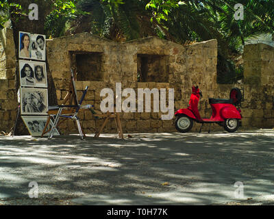 Red vespa Motorrad kunst Porträts und alte Mauer auf der Insel Rhodos, Griechenland. Stockfoto