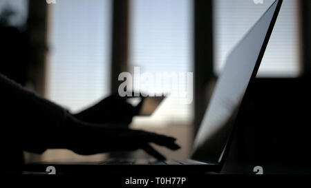 Frau sitzt am Tisch tun online Zahlungen mit Ihrer Kreditkarte über Laptop Stockfoto