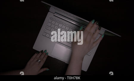 Frau öffnet Laptop, grau Laptop auf einer hölzernen Schreibtisch Stockfoto