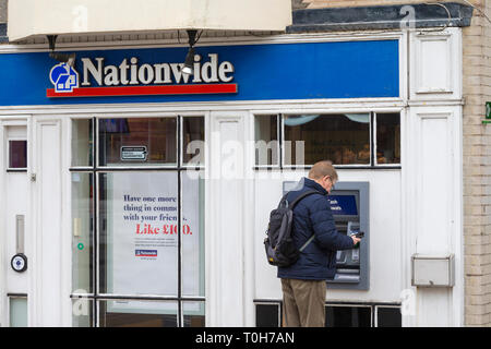 Mann an einem allgemein Cashpoint, Großbritannien Stockfoto