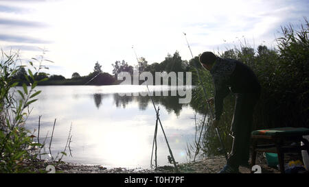 Mann angeln auf dem See, haben Spaß Stockfoto