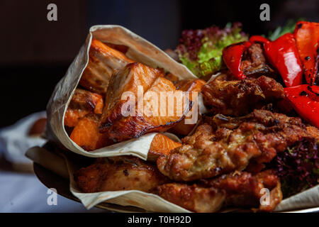 Mixed Grill Fleisch, gebratenes Gemüse und gegrillter Lachs Fischfilets Dekoration in warmen Gericht. Verschiedene köstliche gegrillte Kebab mit Kräutern auf Plat serviert. Stockfoto